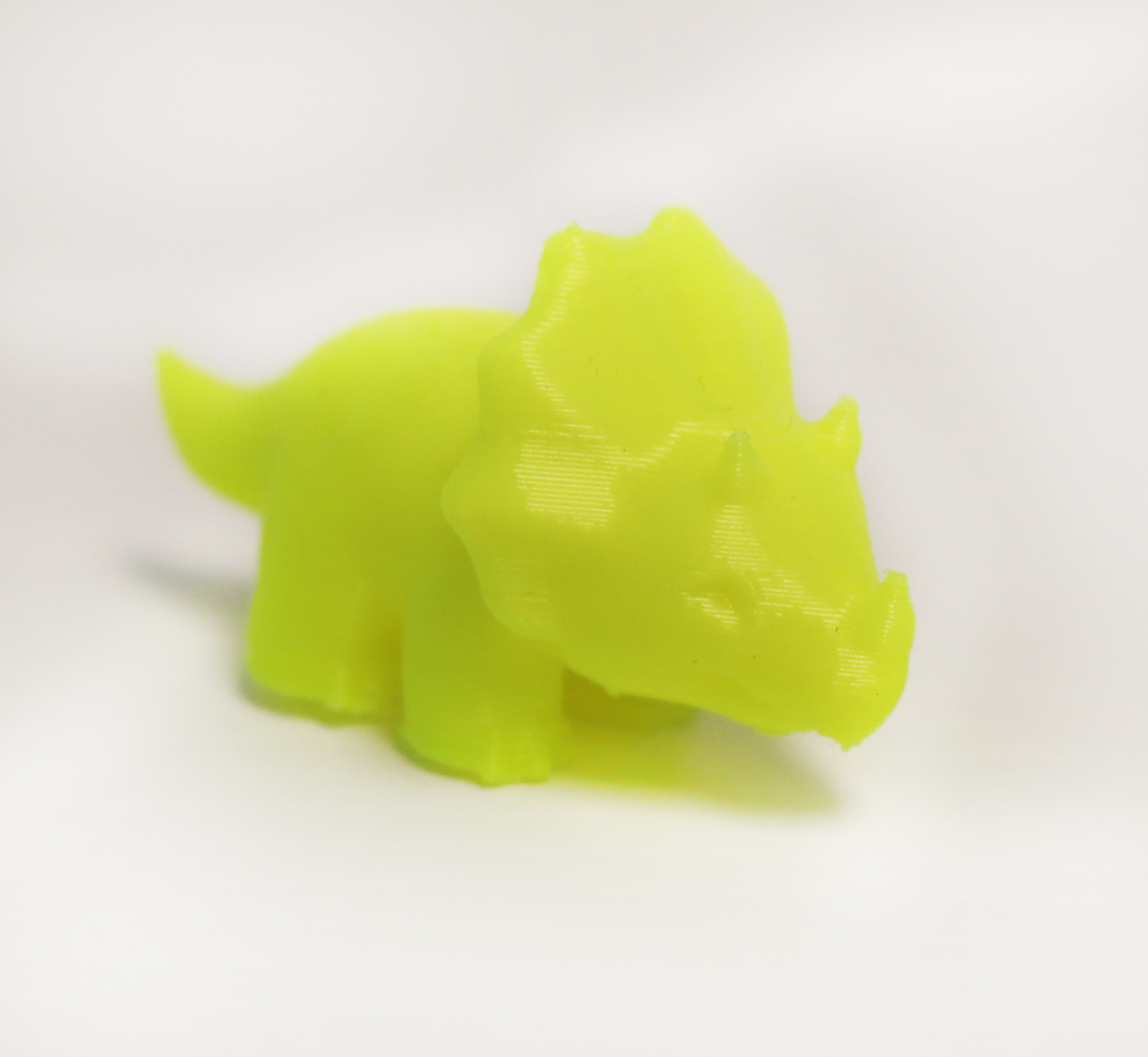 A neon yellow triceratops 3D printable. 